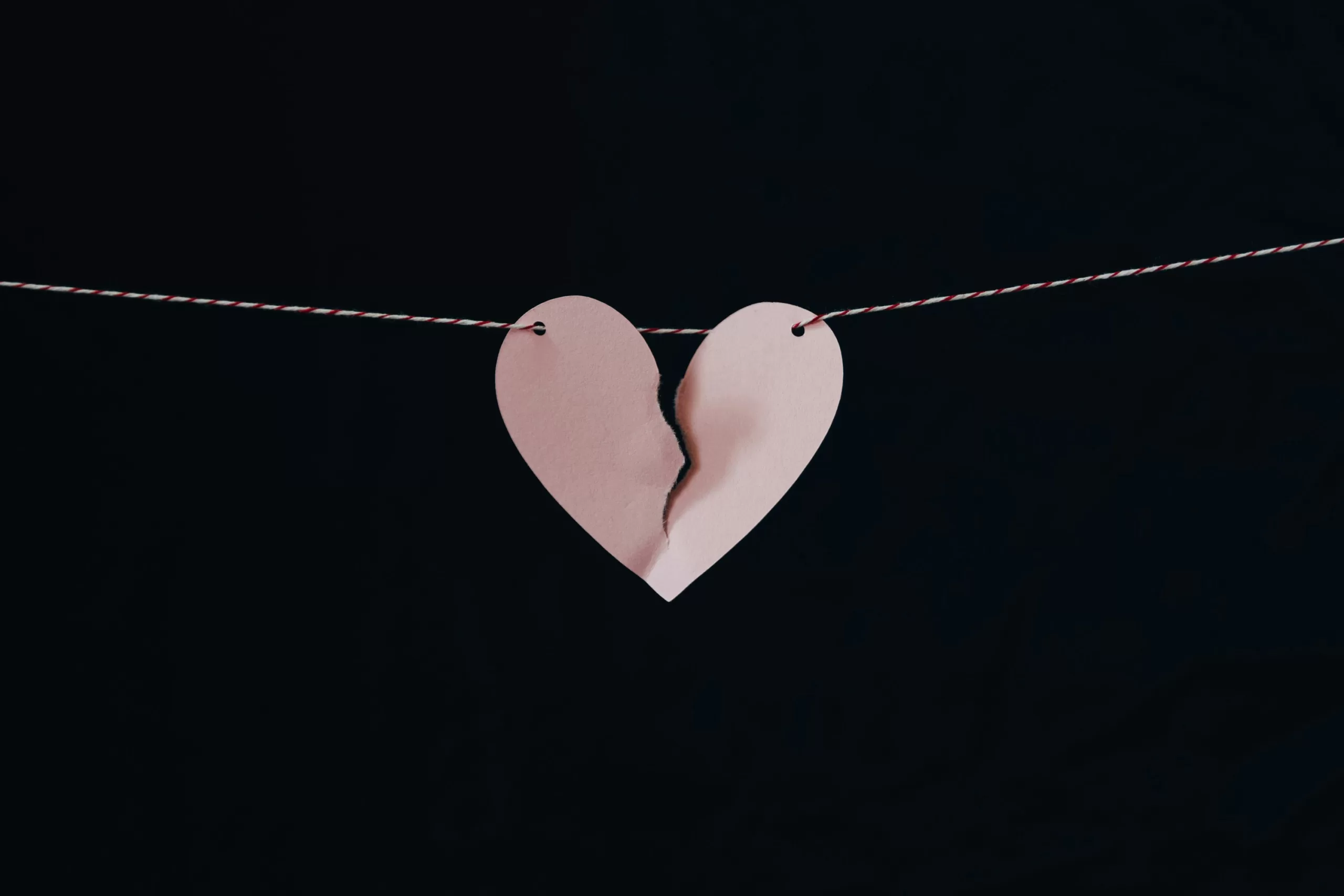 Torn paper heart hanging on a clothes line