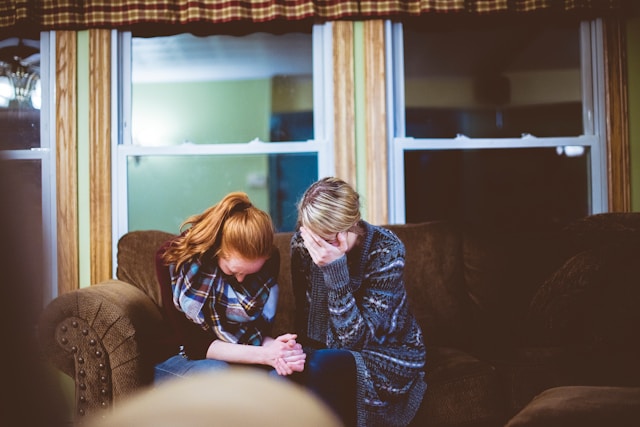 Couple sitting down with their heads in their hands