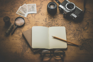 Notebook, camera, magnifying glasses and a map