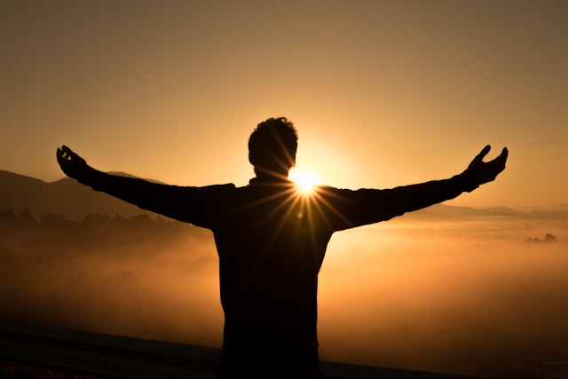 Silhouette of a man with arms spread to the sun