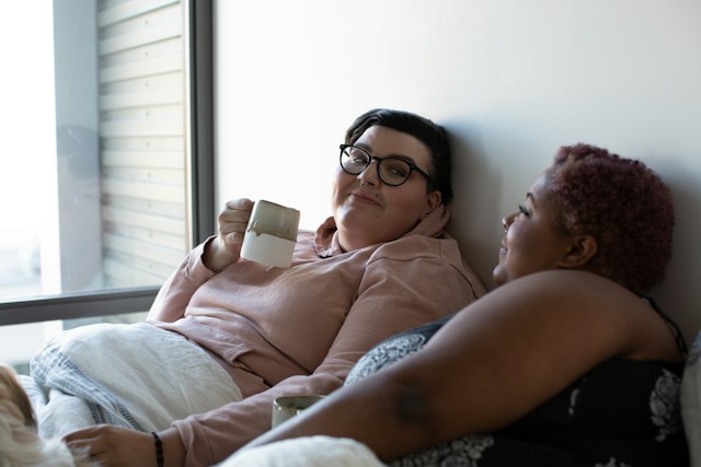 Couple in bed drinking coffee
