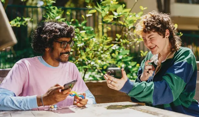Couple smiling and showing phones