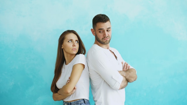 Couple back to back looking unhappy